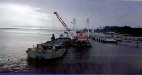 Crane barge memuat material keruk ke hopper barge yang sandar di sisinya
