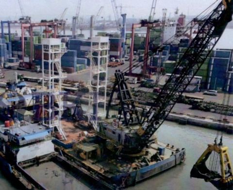 Crane barge dengan grab di depan terminal peti kemas, Jawa Timur